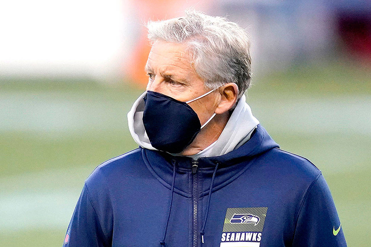 Seattle Seahawks head coach Pete Carroll wears a mask on the field before an NFL football game against the Arizona Cardinals, Thursday, Nov. 19, 2020, in Seattle. (AP Photo/Elaine Thompson)