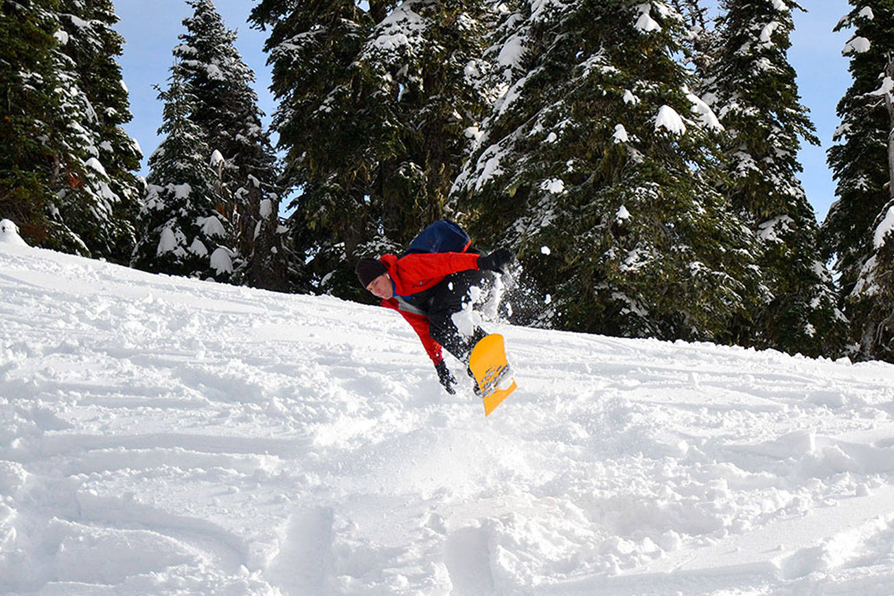 A snowboarder hits a jump on a ski trail at Hurricane Ridge on Friday, Nov. 27, 2020. (Laura Foster/Peninsula Daily News)