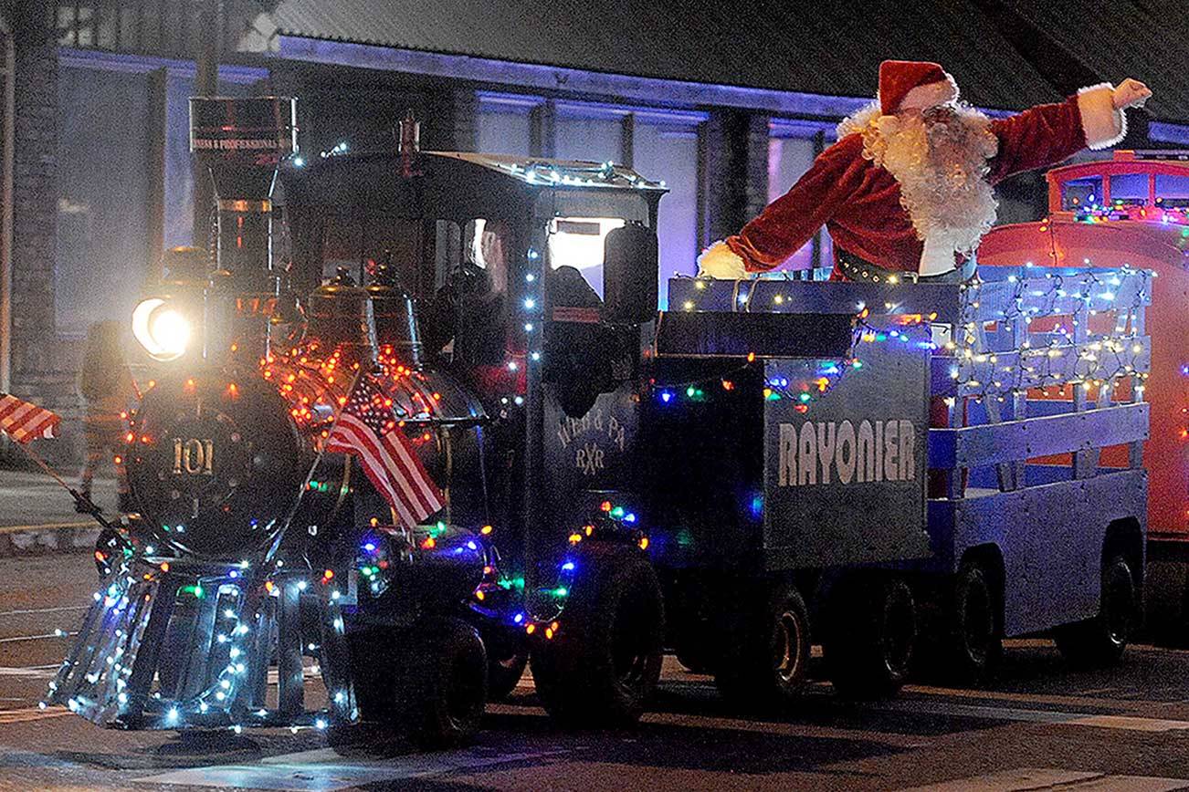 Santa waves to onlookers from the West End Business train during Saturday's Twinkle Light Christmas Parade in Forks. (Lonnie Archibald/For Peninsula Daily News)