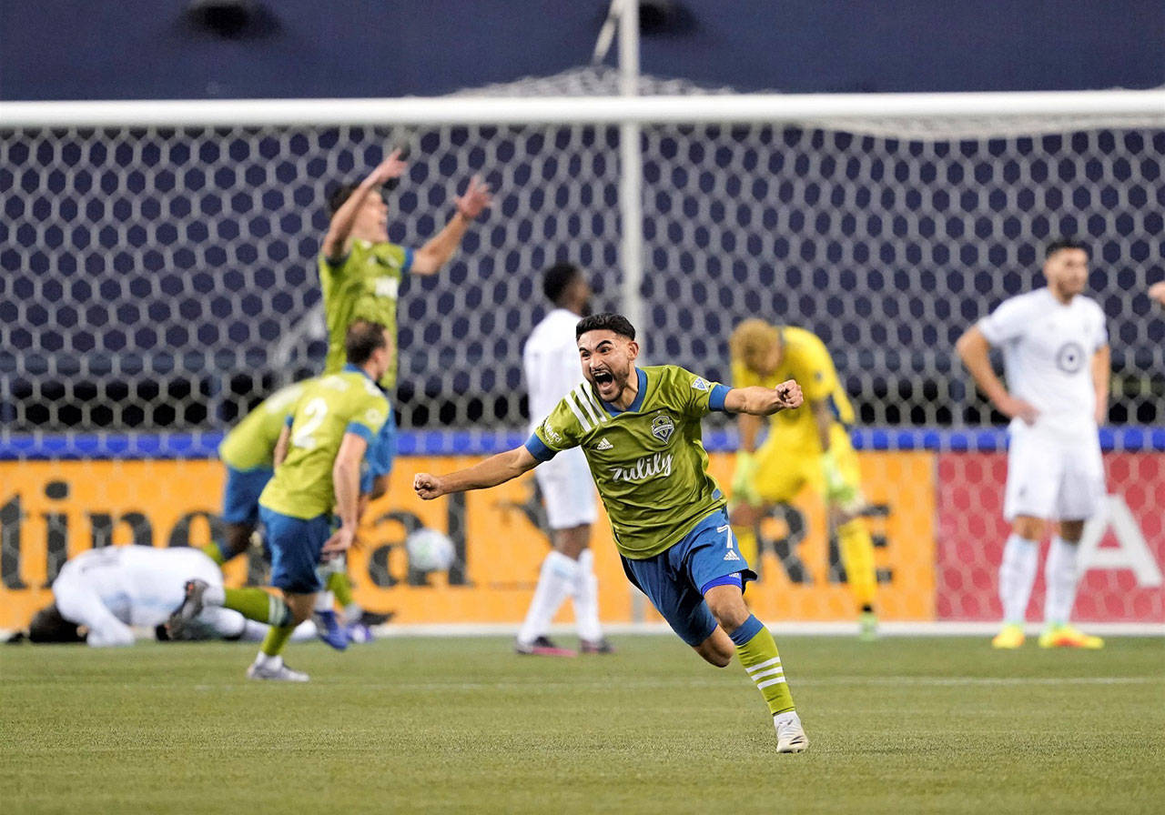 Seattle Sounders’ Cristian Roldan (7) celebrates a Sounders goal late in the second half of an MLS playoff Western Conference against Minnesota United, Monday in Seattle. The Sounders won 3-2. (Ted S. Warren/Associated Press)