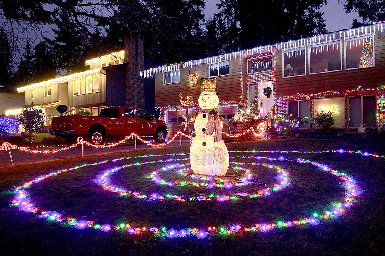 Two houses are decked out with holiday lights in the 1600 block of West 14th Street in Port Angeles. One yard features lights that form a spiral around a snowman. (Dave Logan/For Peninsula Daily News)