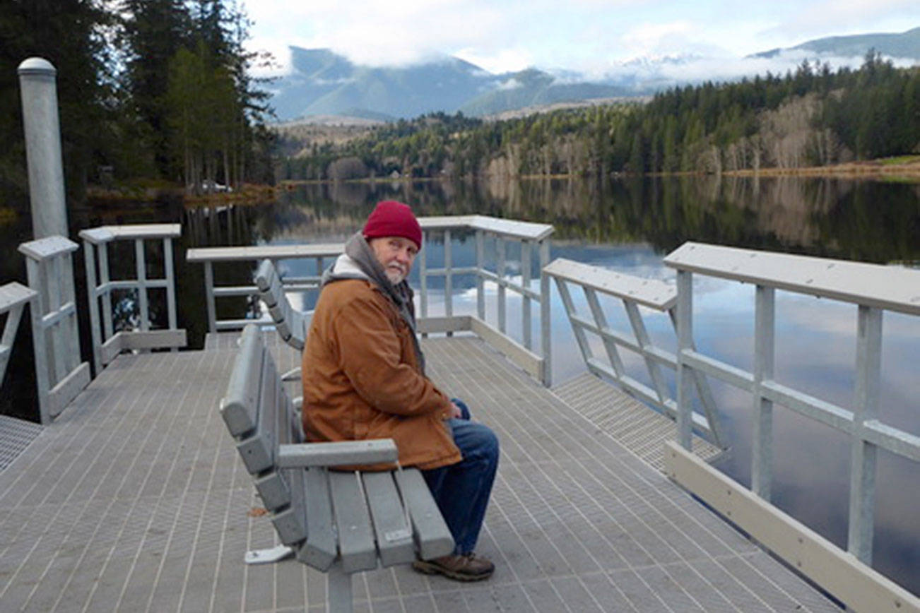 Quilcene's Ward Norden sits on a bench at the recently constructed fishing pier at Lake Leland County Park. The Lake Leland day use park, boat ramp, fishing dock and waterfront area are open after a construction project by the state Department of Fish and Wildlife. (Holly Bauman)