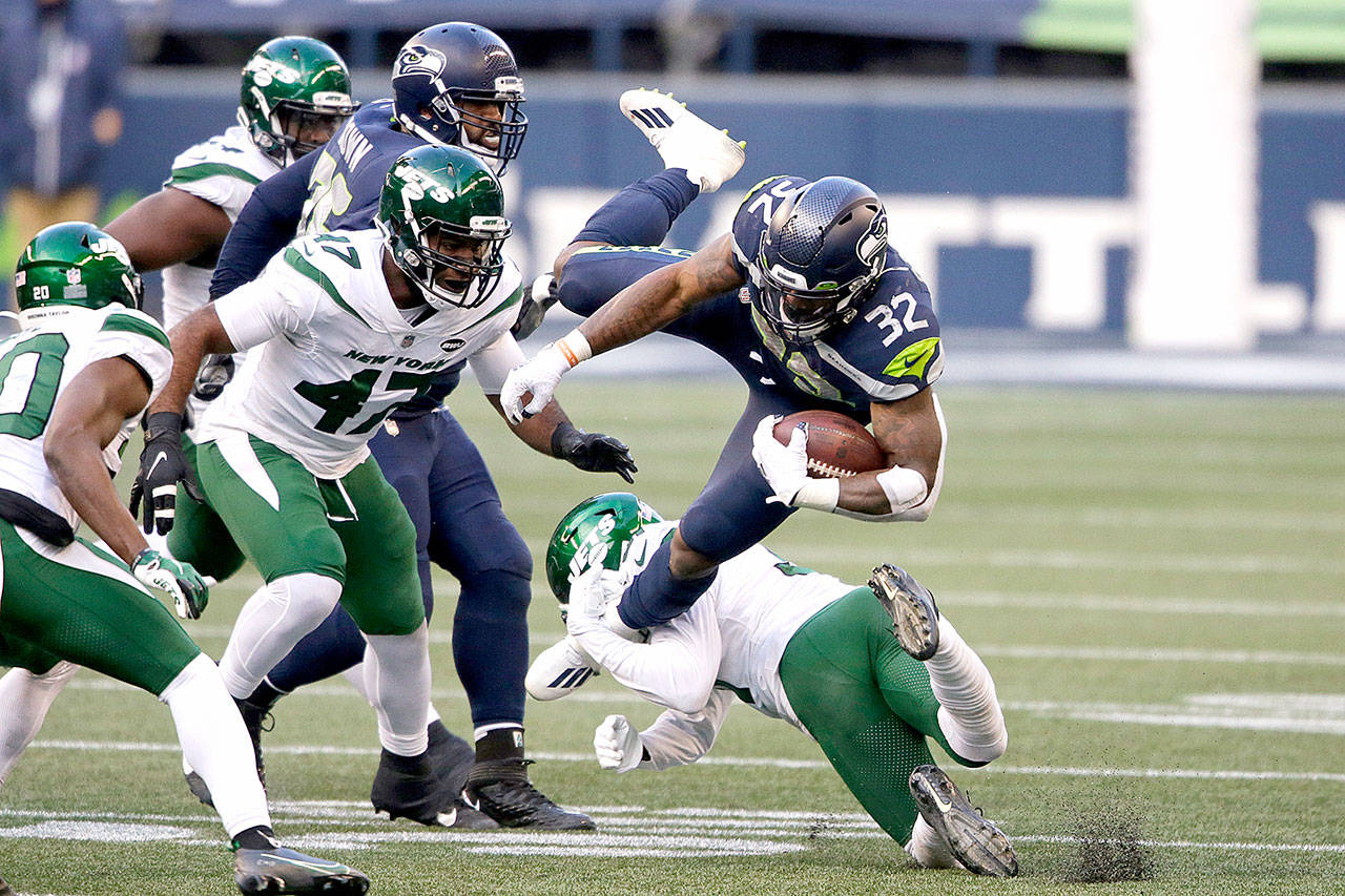 Seattle Seahawks running back Chris Carson (32) is upended on a carry against the New York Jets on Sunday in Seattle. (AP Photo/Lindsey Wasson)