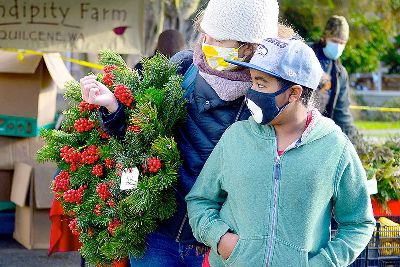 Morgan Hanna, left, and Kenenisa Hanna found a Serendipity Farm wreath at Saturday's Uptown Port Townsend farmers market. The last market of the year is this Saturday from 10 a.m. to 2 p.m. (Diane Urbani de la Paz/Peninsula Daily News)