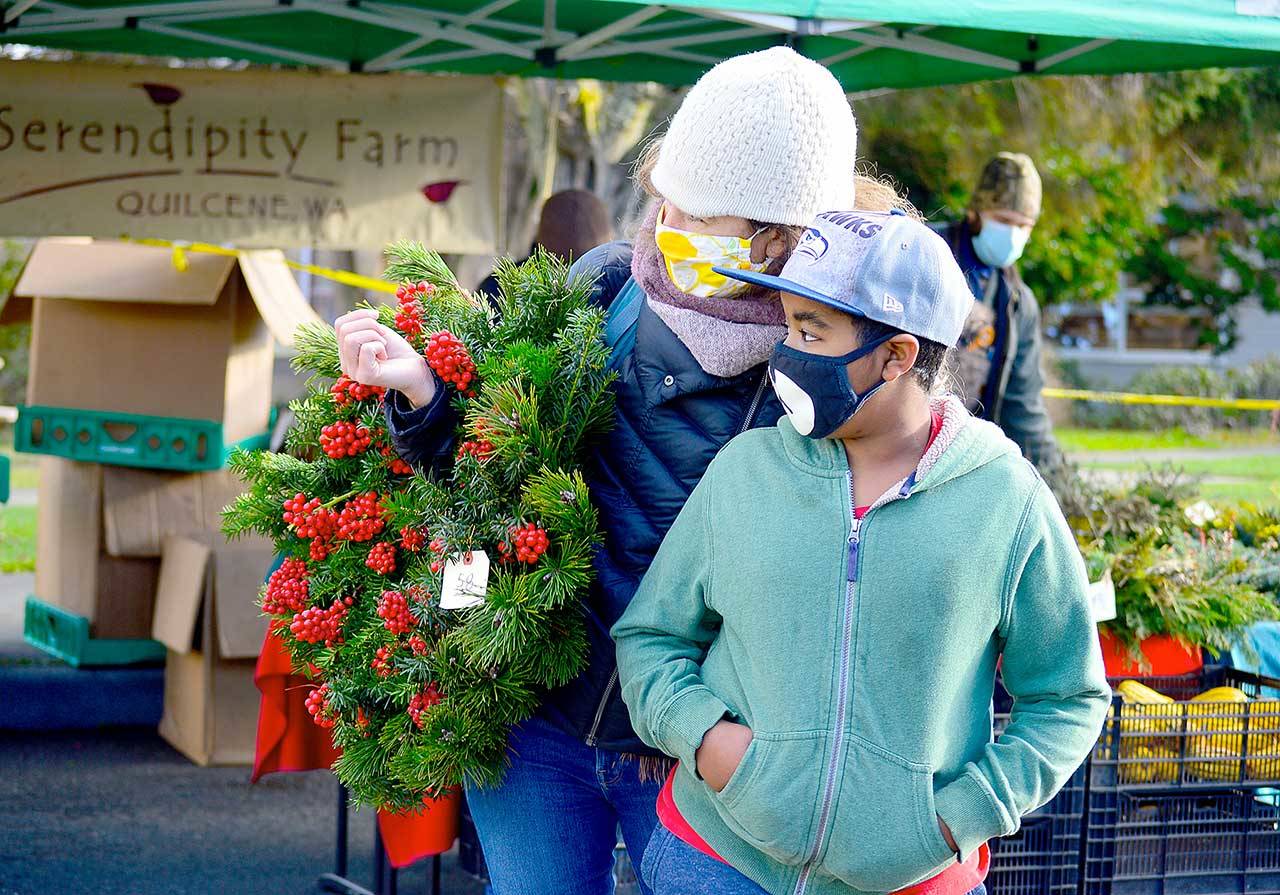 Morgan Hanna, left, and Kenenisa Hanna found a Serendipity Farm wreath at Saturday’s Uptown Port Townsend farmers market. The last market of the year is this Saturday from 10 a.m. to 2 p.m. (Diane Urbani de la Paz/Peninsula Daily News)