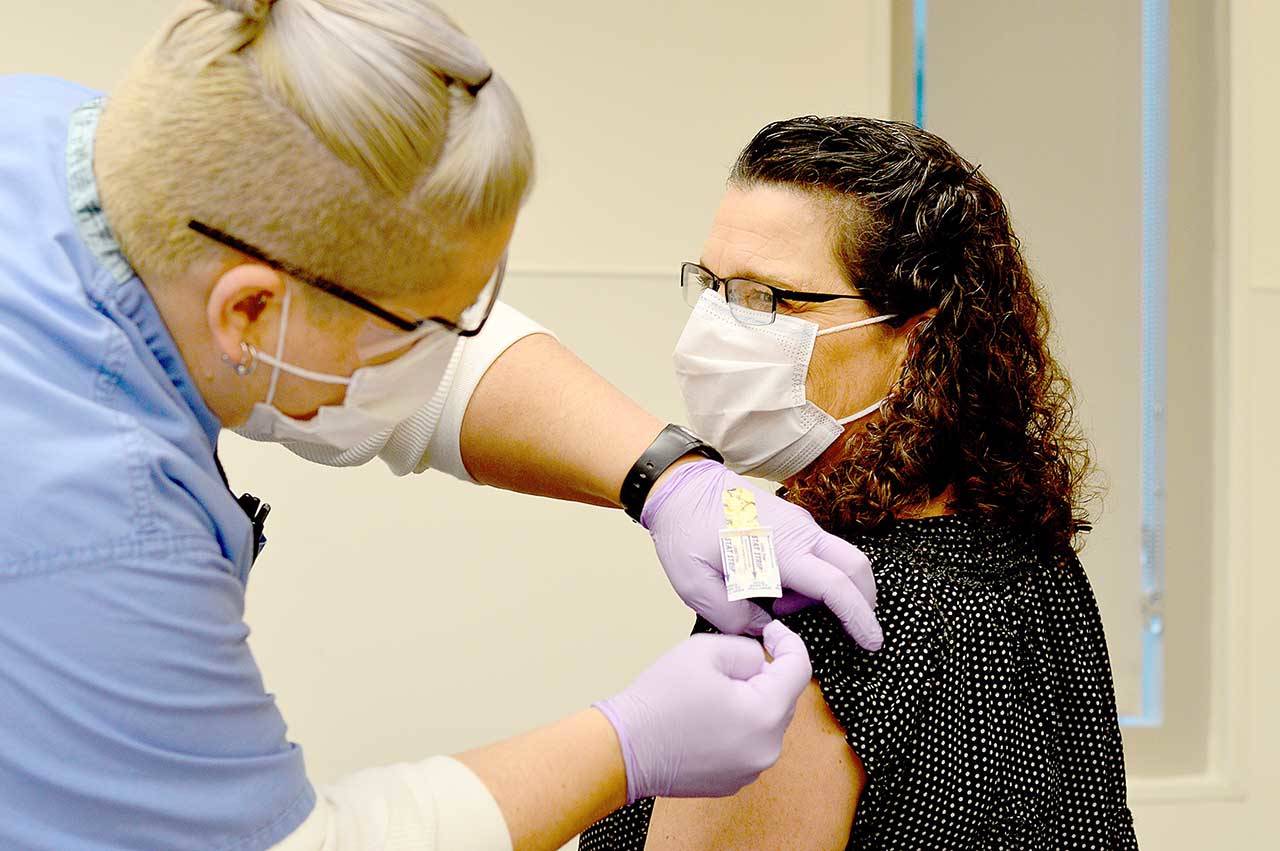 Nurse Jess Cigalotti administers the North Olympic Peninsula’s first COVID-19 vaccine Wednesday, Dec. 16, 2020, to Dr. Tracie Harris, an internist and hospitalist who cares for COVID patients at Jefferson Healthcare hospital. (Diane Urbani de la Paz/Peninsula Daily News)