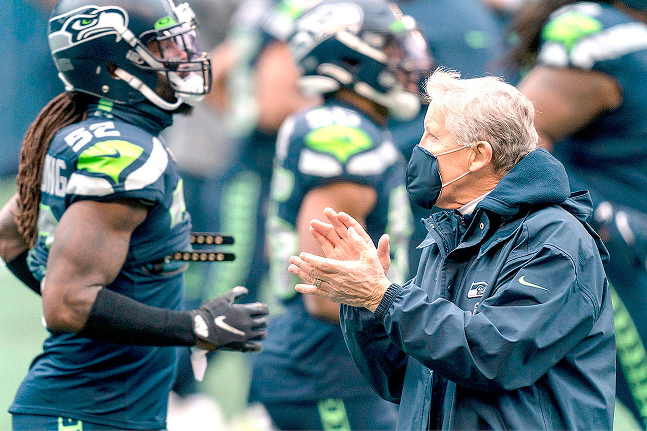 Seattle Seahawks head coach Pete Carroll claps as player warmup around him before an NFL football game against the New York Jets, Sunday, Dec. 13, 2020, in Seattle. The Seahawks won 40-3. (AP Photo/Stephen Brashear)