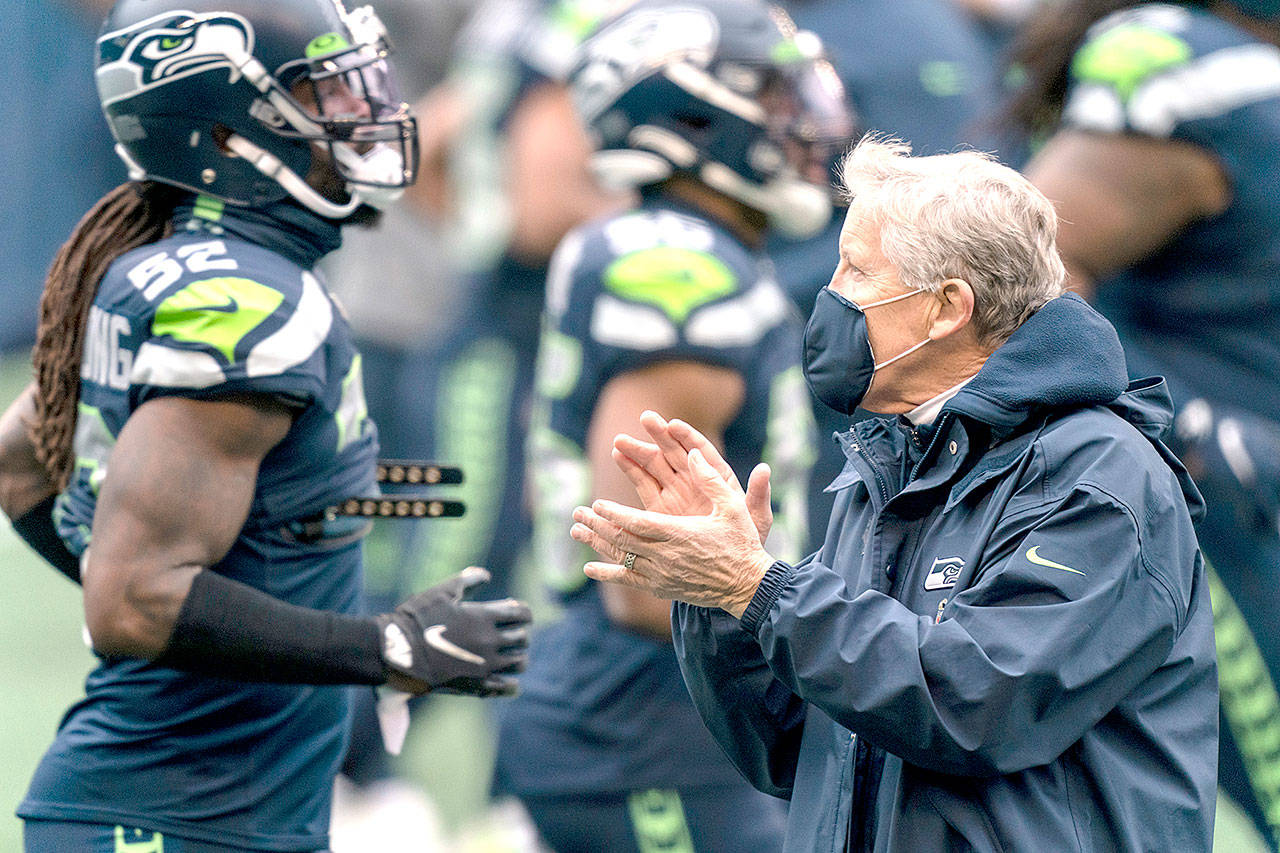 Seattle Seahawks head coach Pete Carroll claps as player warmup around him before an NFL football game against the New York Jets on Sunday, Dec. 13, 2020, in Seattle. The Seahawks won 40-3. (Stephen Brashear/Associated Press)