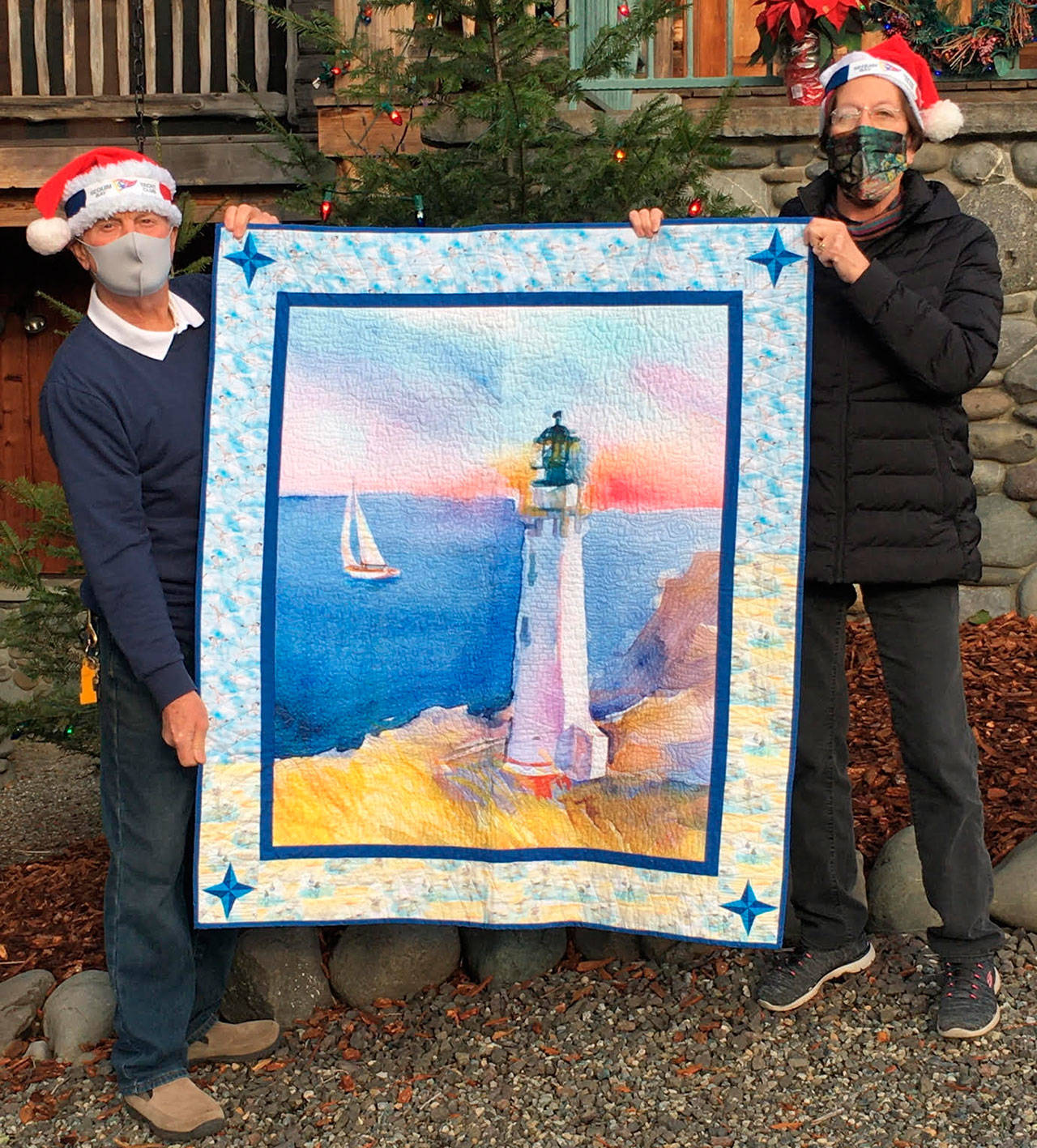 Beverly Nelson receives the Sequim Bay Yacht Club’s 2020 hospice quilt raffle in early December from commodore Jerry Fine. (Submitted photo)