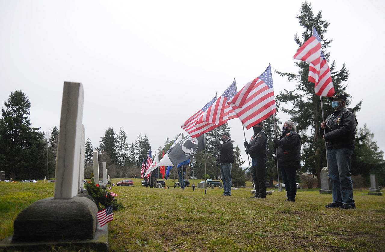 Members of the Clallam County Legion Riders Post 29 create a flag line as a patriotic backdrop to the Wreaths Across America event held. Dec. 19 at Sequim View Cemetery. (Michael Dashiell/Olympic Peninsula News Group)