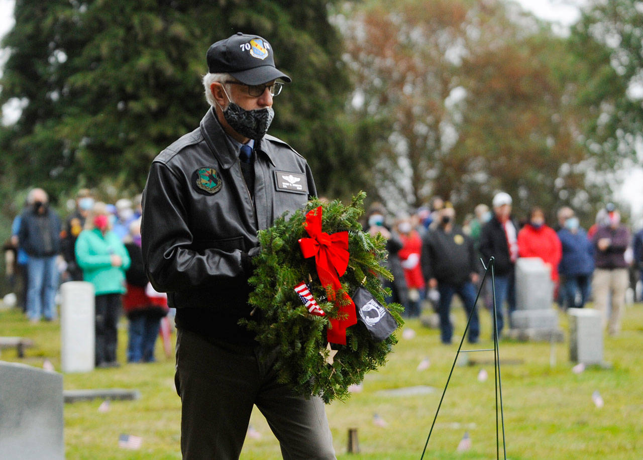 Col. Randy Roberts (U.S. Air Force, retired) prepares to lay a ceremonial wreath for U.S. military prisoners of war and missing in action during Saturday’s Wreaths Across America event at Sequim View Cemetery. (Michael Dashiell/Olympic Peninsula News Group)