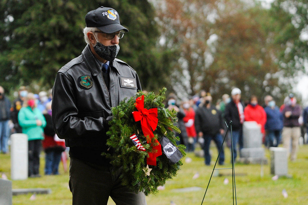 Col. Randy Roberts (U.S. Air Force, retired) prepares to lay a ceremonial wreath for U.S. military prisoners of war and missing in action during Saturday's Wreaths Across America event at Sequim View Cemetery. (Michael Dashiell/Olympic Peninsula News Group)