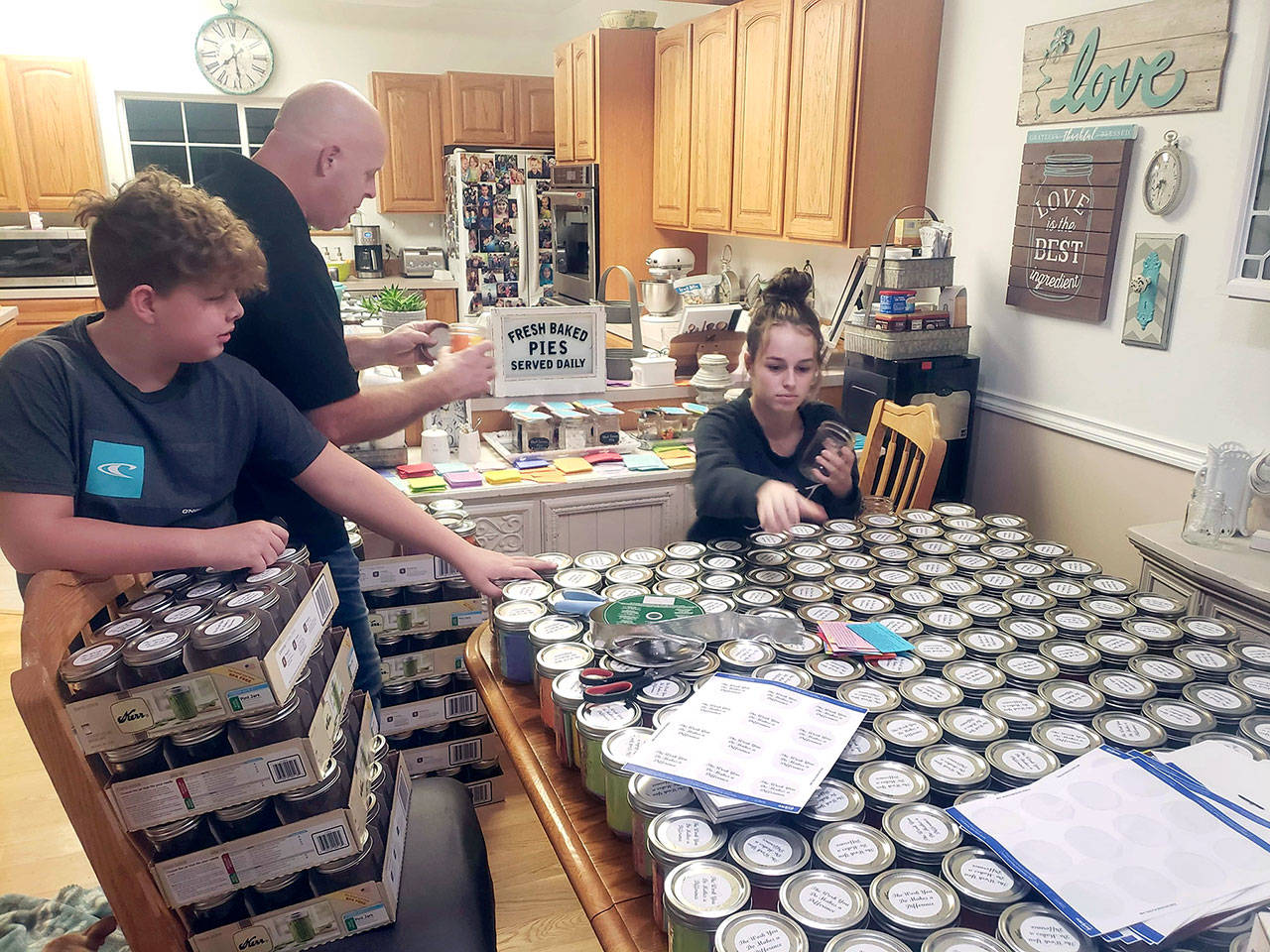 The family of Leslee Francis, Olympic Peninsula Healthy Communities Coalition executive director, son, Austin, 11, husband, Doug, and daughter ,Savannah, 13, help arrange 350 jars of kindness for disitribution to Clallam County behavioral health workers. (Courtesy photo)