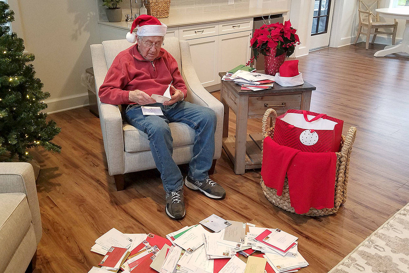 Rodney Hofman opens one of hundreds of Christmas cards sent to hime and fellow Dungeness Courte Memory Care residents following a request from Hofman's family members on social media. (Dungeness Courte Memory Care)