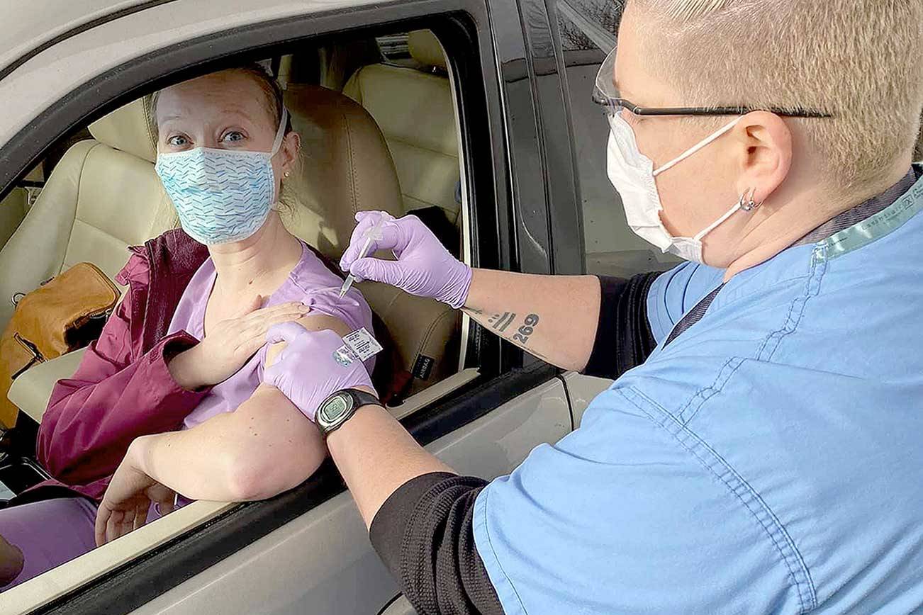 Nurse Jess Cigalotti administers the COVID-19 vaccine to Jefferson Healthcare laboratory staffer Lindsay Laughlin at the drive-up site in Port Townsend. More than 750 frontline healthcare workers will have made their immunization appointments by the end of today.