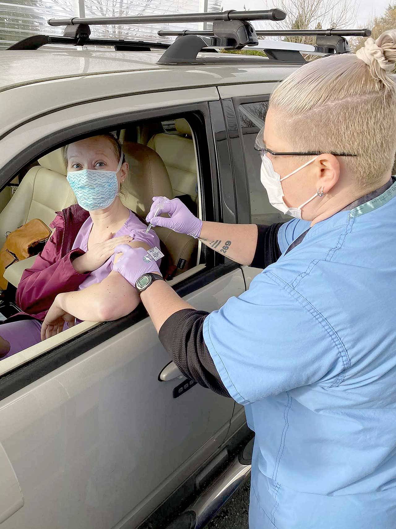 Nurse Jess Cigalotti administers the COVID-19 vaccine to Jefferson Healthcare laboratory staffer Lindsay Laughlin at the drive-up site in Port Townsend. More than 750 frontline healthcare workers will have made their immunization appointments by the end of today. (Courtesy photo)