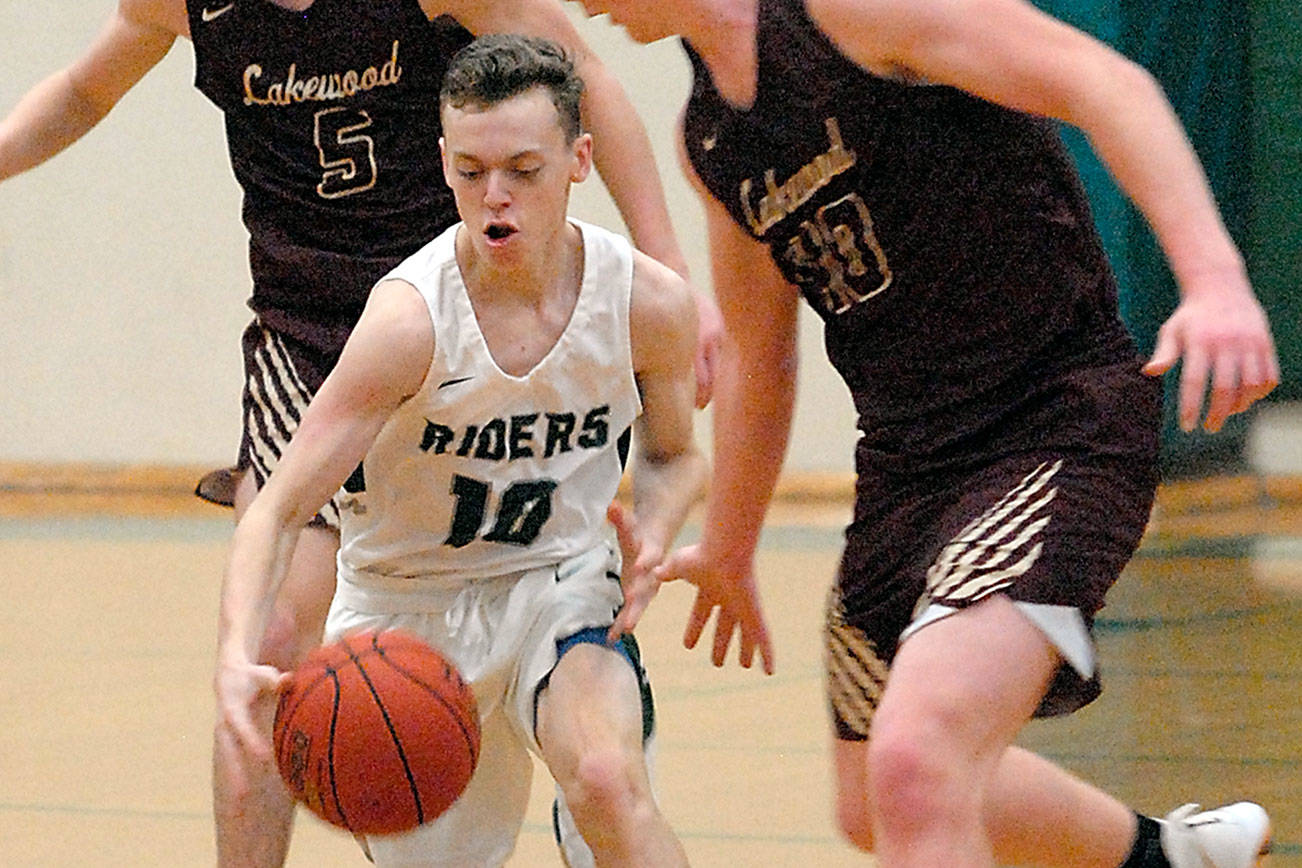 Port Angeles’ Dru Clark, center, drives down the court surrounded by Lakewood’s Shae Dixon, left, and Andrew Molloy during a 2019 game in Port Angeles. (Keith Thorpe/Peninsula Daily News)