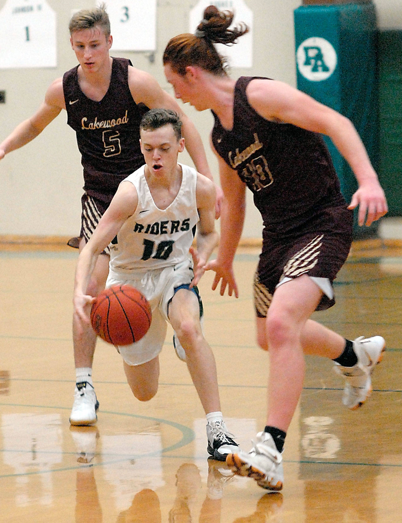 Port Angeles Dru Clark, center, drives down the court surrounded by Lakewoods Shae Dixon, left, and Andrew Molloy during a 2019 game in Port Angeles. (Keith Thorpe/Peninsula Daily News file)