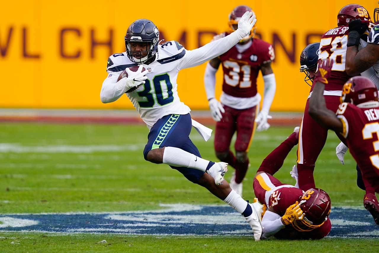 Seattle Seahawks running back Carlos Hyde (30) breaks away from Washington Football Team cornerback Ronald Darby (23) to begin his 50-yard touchdown run during the second half of an NFL football game Dec. 20 in Landover, Md. (Susan Walsh/Associated Press)