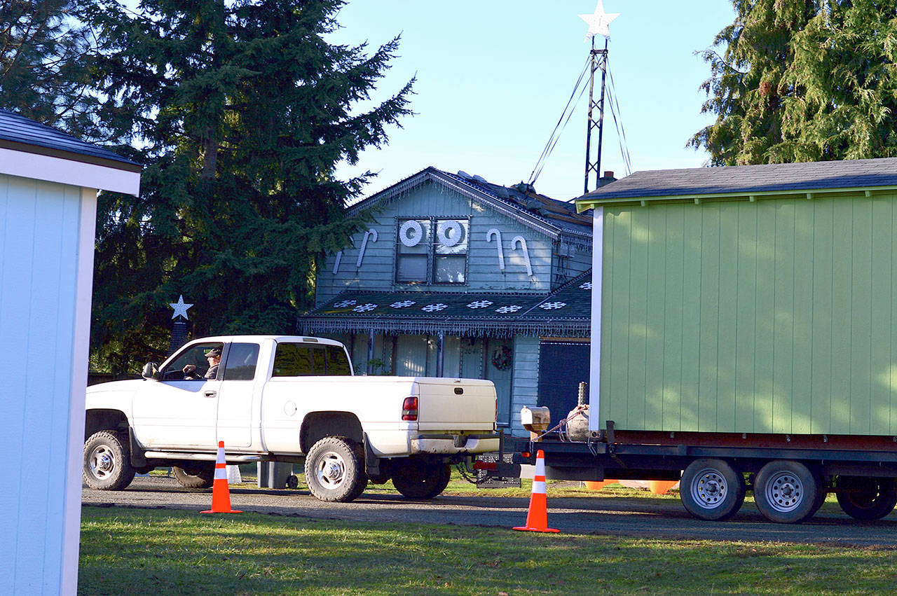 Mover Jon Piskula drives the first of five houses away from the Community Build construction site in Port Townsend, heading for the new village in Port Hadlock. (Diane Urbani de la Paz/Peninsula Daily News)
