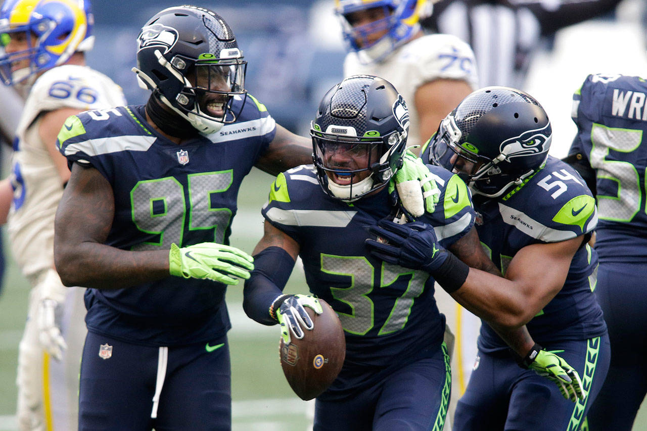 Seattle Seahawks free safety Quandre Diggs (37) reacts with defensive end Benson Mayowa (95) and linebacker Bobby Wagner (54) after Diggs intercepted a pass during the first half of an NFL football game against the Los Angeles Rams on Sunday in Seattle. (Scott Eklund/Associated Press)