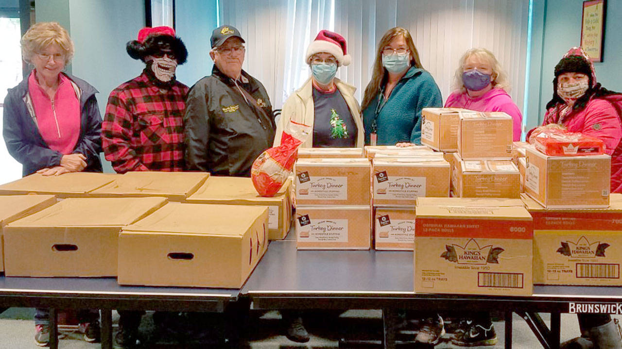 Helga Greer, left, Randy Yard, Charlie Johnson, Maura Mattson, Jennifer Petty, Valerie Brooks and Cat Yard, members of Sequim Elks Lodge No. 2642 and staff of the Clallam County Juvenile and Family Services’ child advocate program, pause in delivering Christmas meals to foster families. The lodge used a $3,500 Beacon Grant from the Elks National Foundation to purchase 50 complete dinners for the foster families in the program.