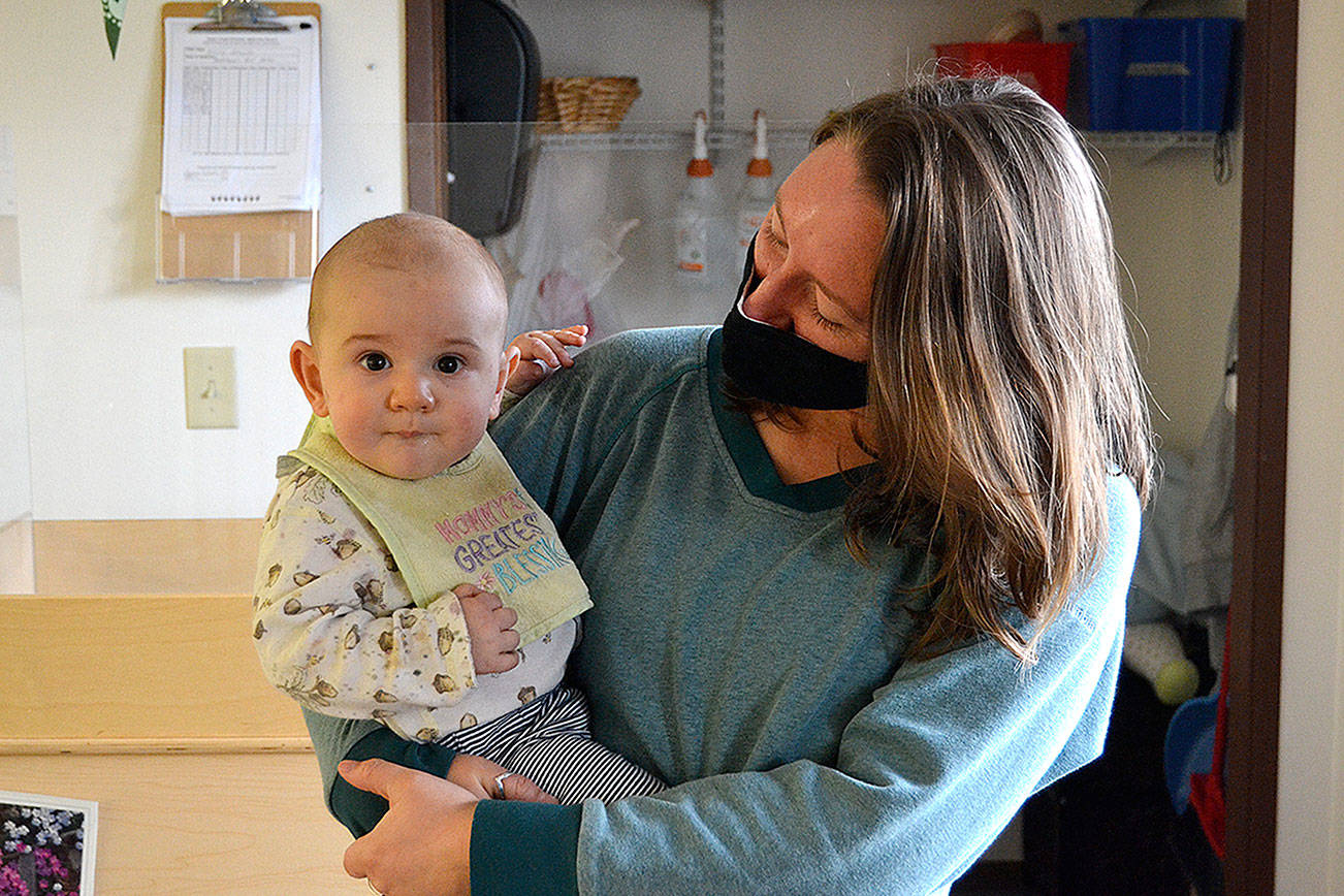Matthew Nash/Olympic Peninsula News Group 

Bethany McKim, infant room teacher at Sequim’s Little Explorers Early Learning Center, cares for 7-month-old Oisin last month. Owners of the center said they’ve had difficulty hiring during the pandemic, and that has led to limited hours.