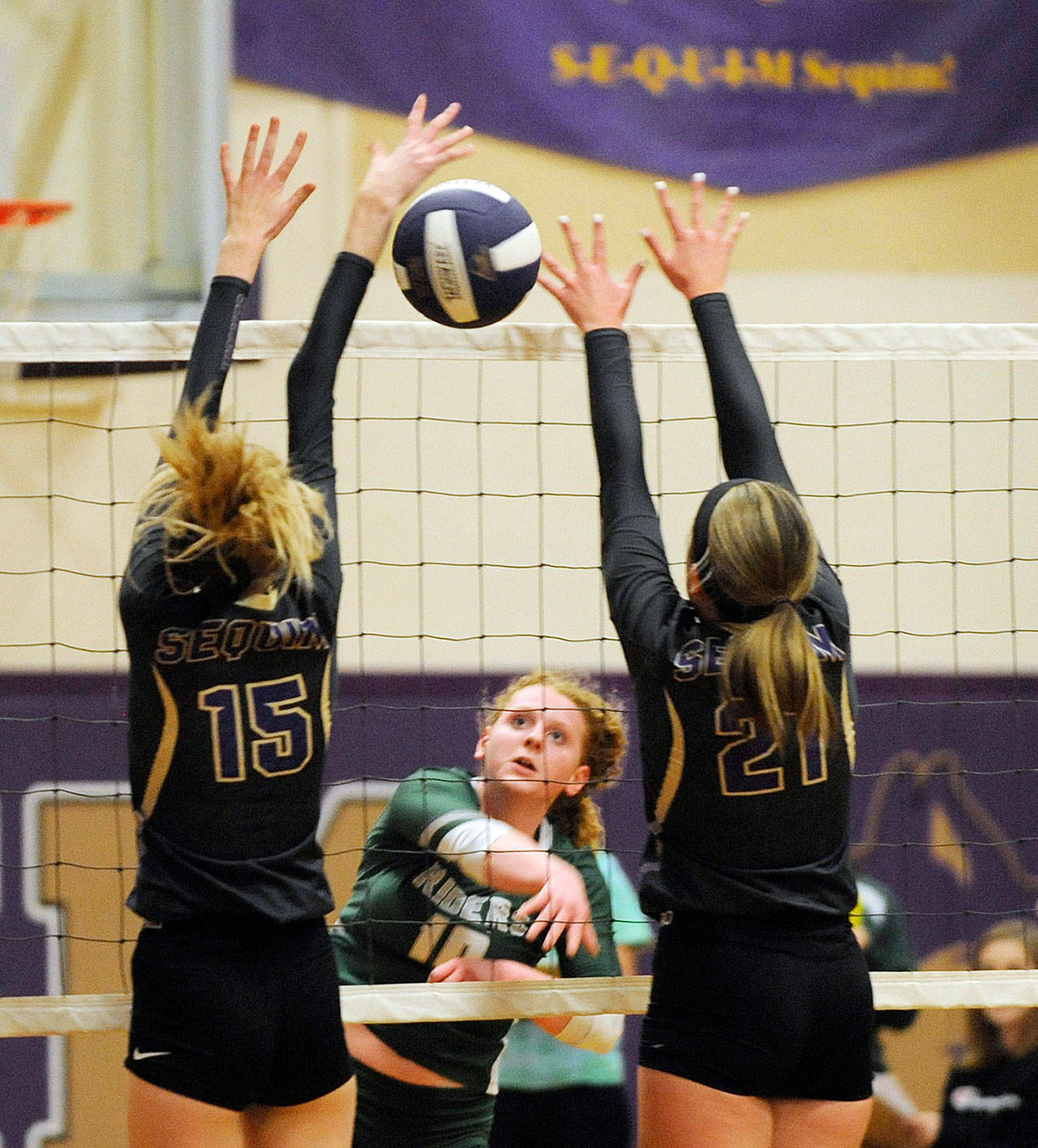 Port Angeles’ Kennedy Bruch, center, returns the volleyball between the hands of Sequim’s Kendall Hastings, left, and Kali Wiker during an October 2019 match in Sequim. (Michael Dashiell/Olympic Peninsula News Group file)