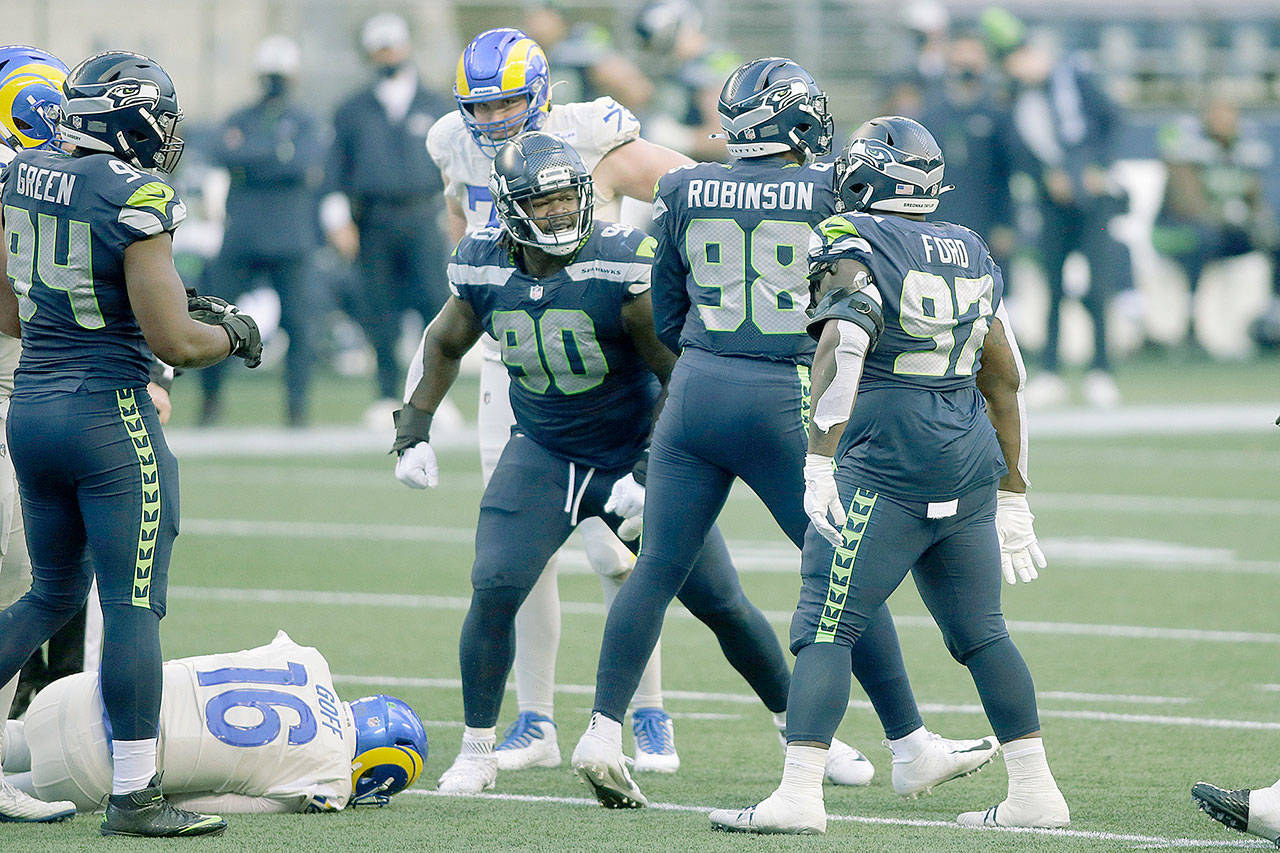 Seattle Seahawks defensive end Alton Robinson (98) reacts with teammates after he sacked Los Angeles Rams quarterback Jared Goff (16) during the second half of an NFL football game Sunday, Dec. 27, 2020, in Seattle. (Scott Eklund/The Associated Press)