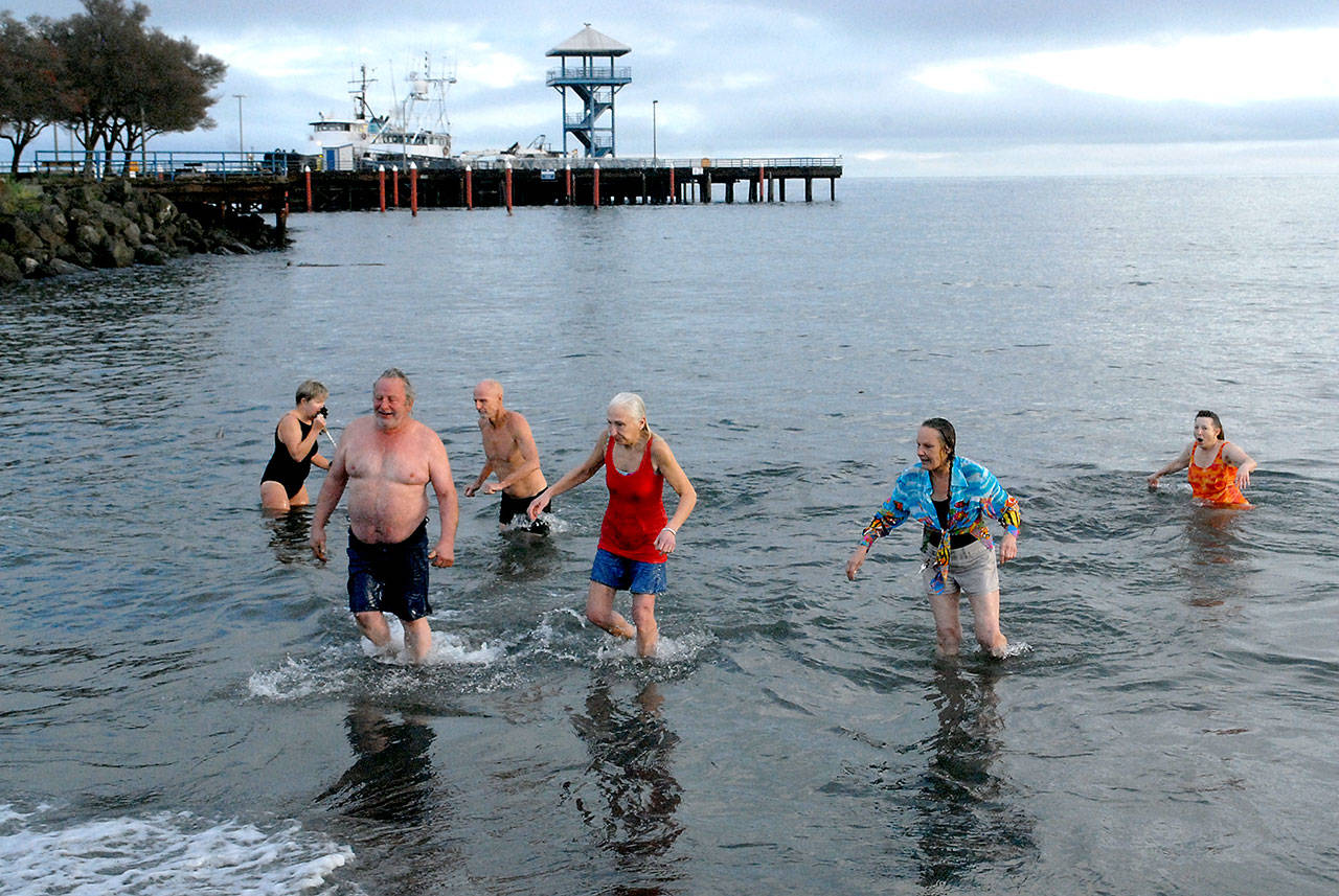 Polar Bear participants emerege from the chilly water of Port Angeles Harbor during Fridays New Years Day plunge at Hollywood Beach. Although there was no organized event this year due to COVID-19 restrictions, many people showed up anyway to run to take part in the annual ritual. (Keith Thorpe/Peninsula Daily News)