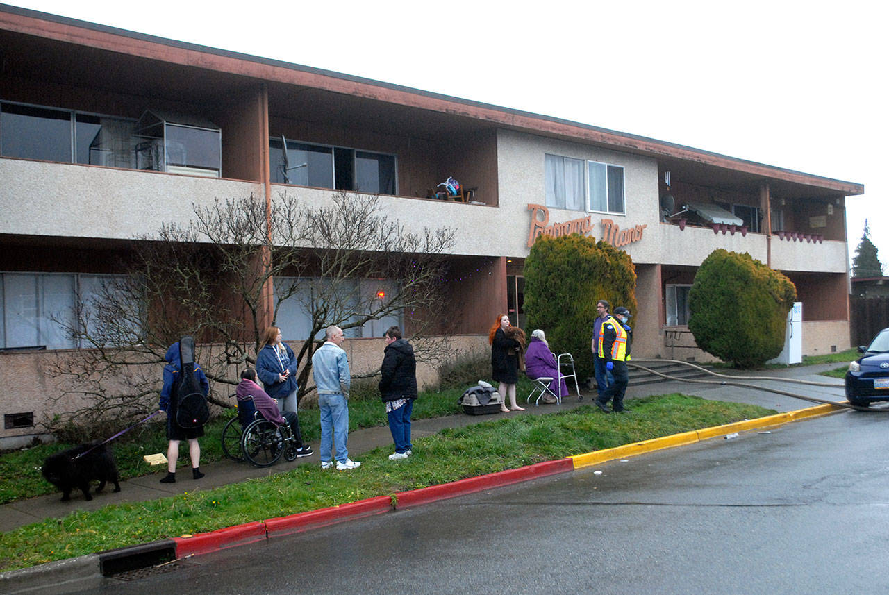 Residents of the Panorama Manor Apartments in Port Angeles wait outside the building after fire broke out in one of the units on Friday afternoon. (Keith Thorpe/Peninsula Daily News)
