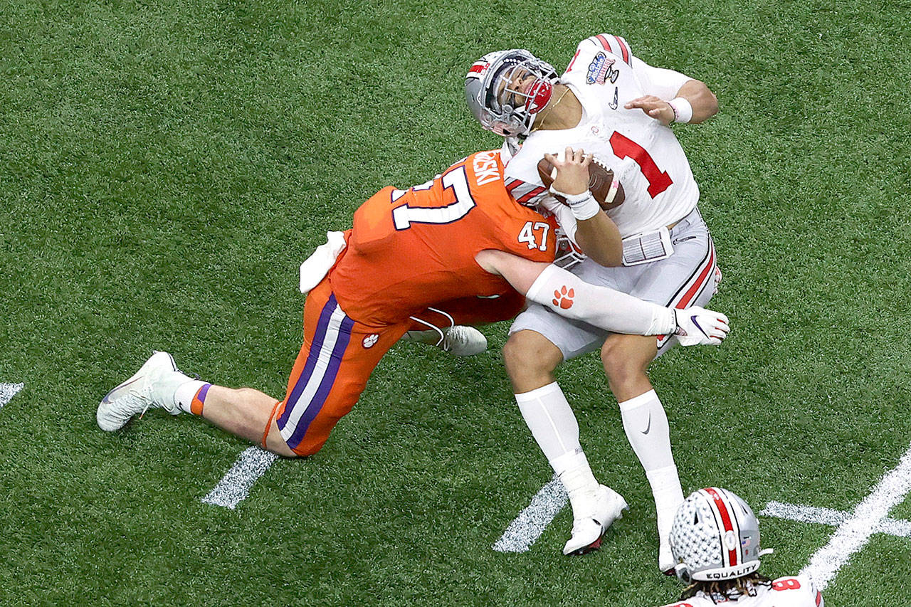 Ohio State quarterback Justin Fields gets hit by Clemson linebacker James Skalski during the first half of the Sugar Bowl Friday night in New Orleans. Skalski was ejected from the game for targeting. (AP Photo/Butch Dill)