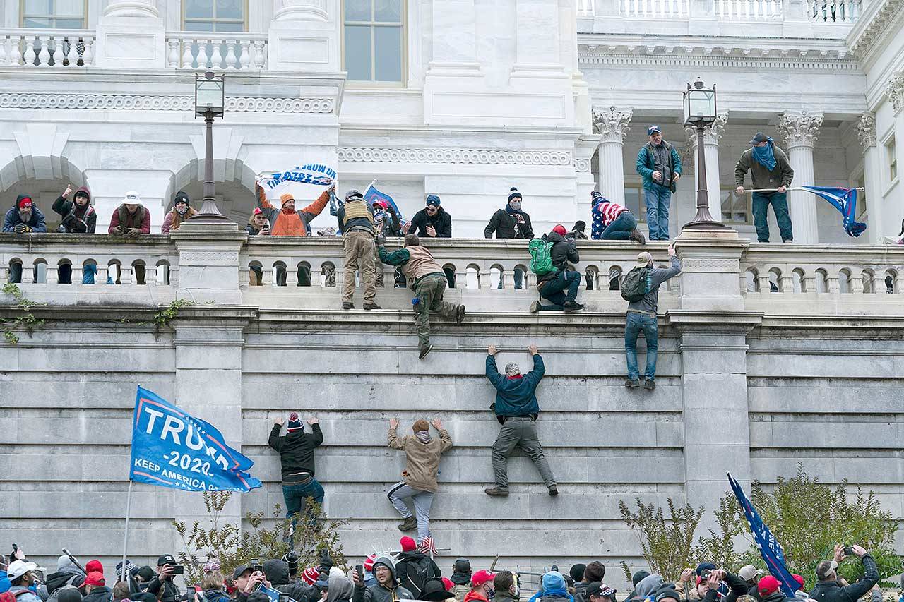 Supporters of President Donald Trump climb the west wall of the the U.S. Capitol on Wednesday in Washington, D.C. (Jose Luis Magana/The Associated Press)