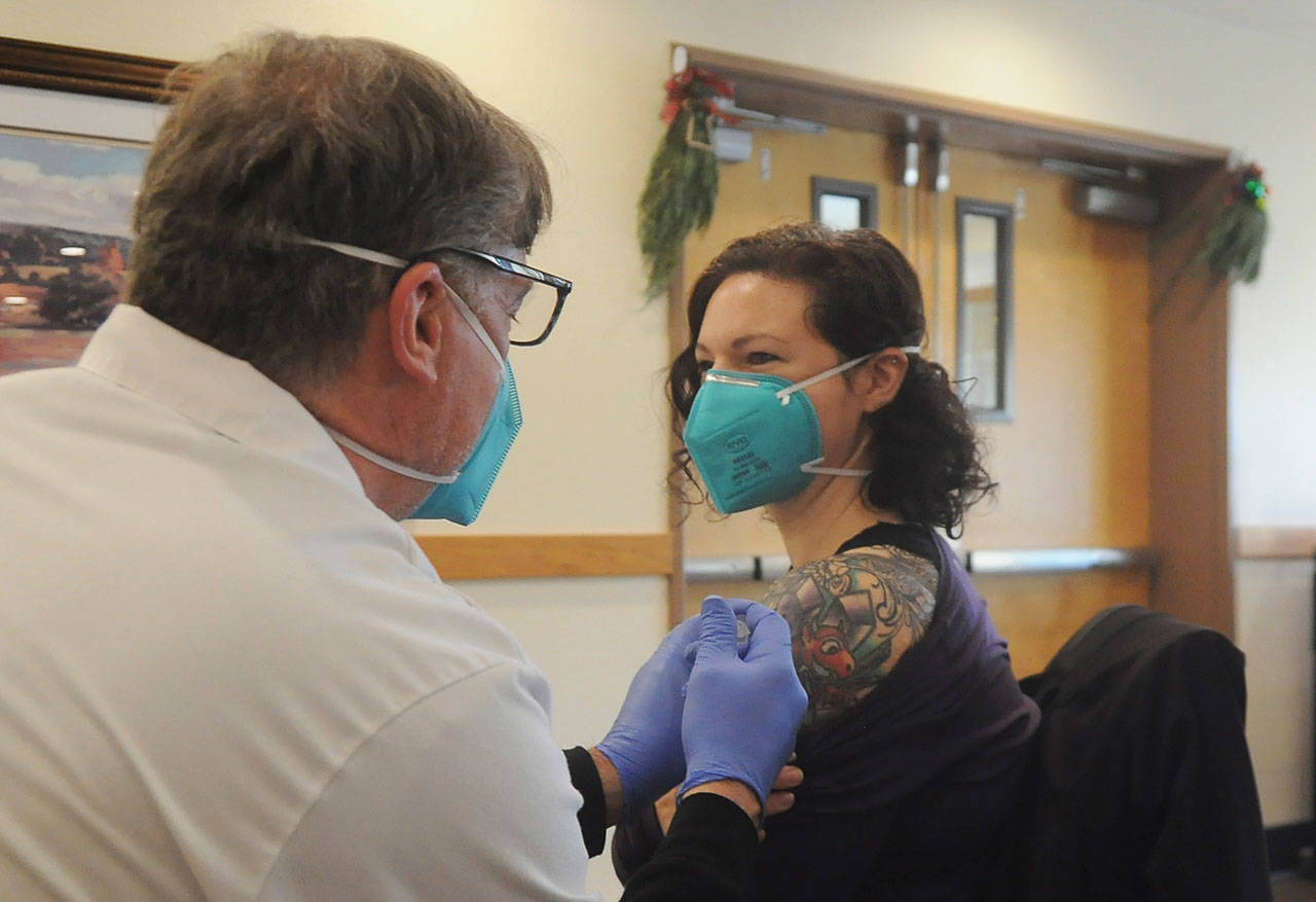 <strong>Michael Dashiell</strong>/Olympic Peninsula News Group
Robin Worth-McIntyre, a nurse technician at Avamere Olympic Rehabilitation of Sequim, gets a Pfizer COVID-19 vaccine shot from Walgreens pharmacist Steve Sommers.