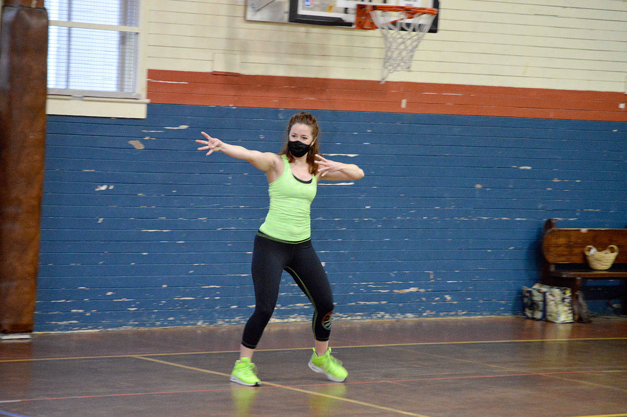 Independent Zumba instructor Bailey Burkhartsmeier teaches a spread-out, masked class for a handful of students at the Port Townsend Community Center on Tuesday morning. Statewide guidelines allowing in-person exercise with restrictions are inspiring fitness enthusiasts to come back to gyms and yoga studios this week. (Diane Urbani de la Paz/Peninsula Daily News)