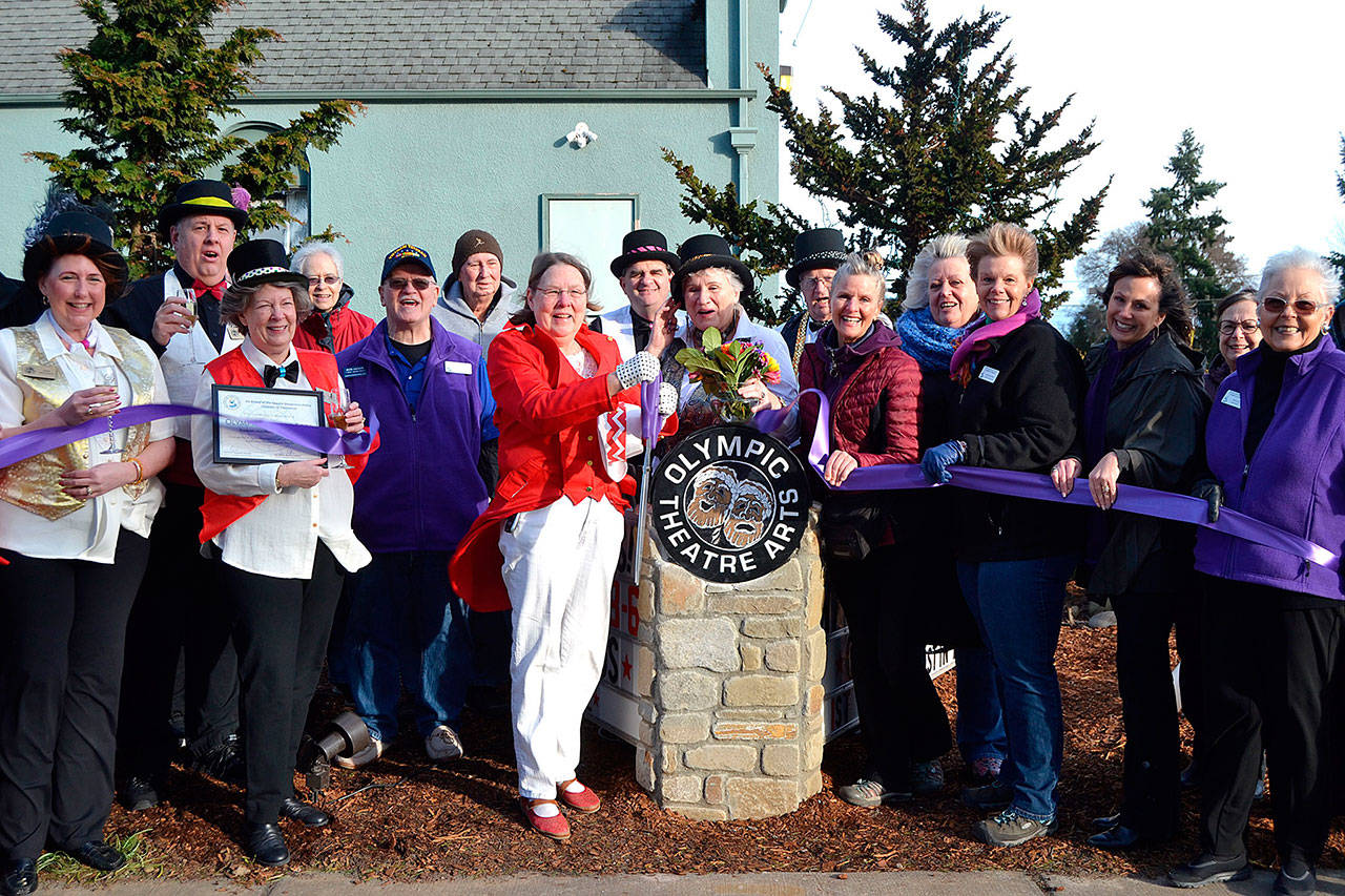 Executive Director Carol Willis, center left, cuts the Olympic Theater Arts Ribbon ??  new sign on February 1, 2020, as part of an open house with theater supporters and members of the Sequim-Dungeness Valley Chamber of Commerce.  Willis recently left his OTA position due to health issues.