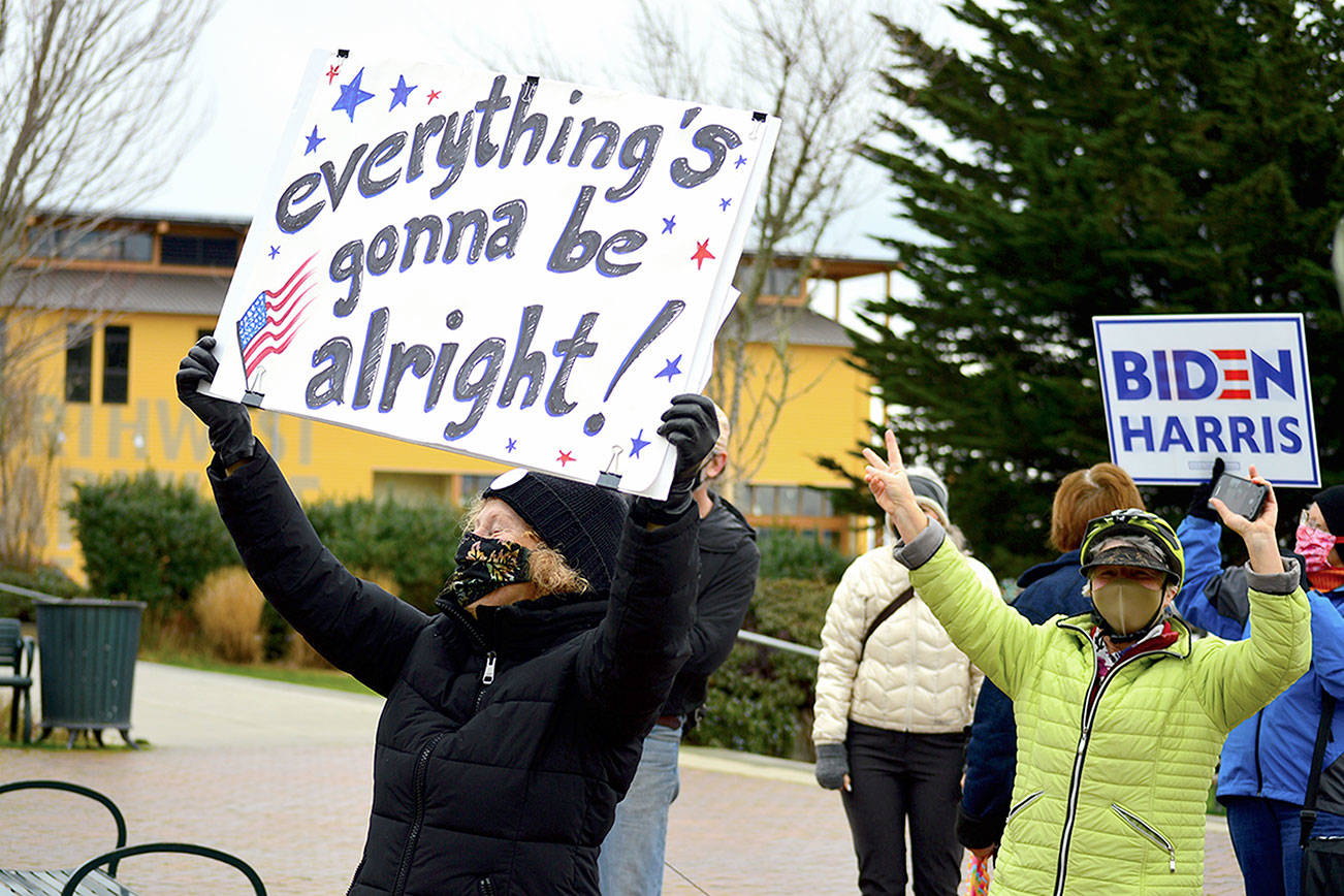 As motorists honked, Linda Abbott-Roe held up her message during the Inauguration Day celebration in downtown Port Townsend. (Diane Urbani de la Paz/Peninsula Daily News)
