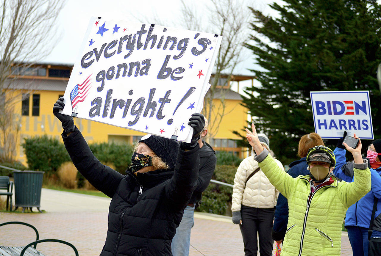 As motorists honked, Linda Abbott-Roe held up her message during the Inauguration Day celebration in downtown Port Townsend. (Diane Urbani de la Paz/Peninsula Daily News)