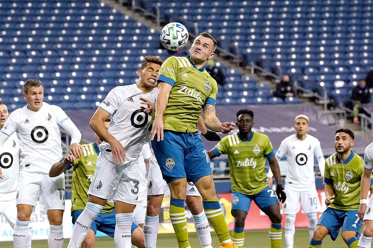 Minnesota United midfielder Hassani Dotson, front left, and Seattle Sounders forward Jordan Morris leap to head the ball during the first half of an MLS playoff Western Conference final soccer match, Monday, Dec. 7, 2020, in Seattle. (AP Photo/Ted S. Warren)