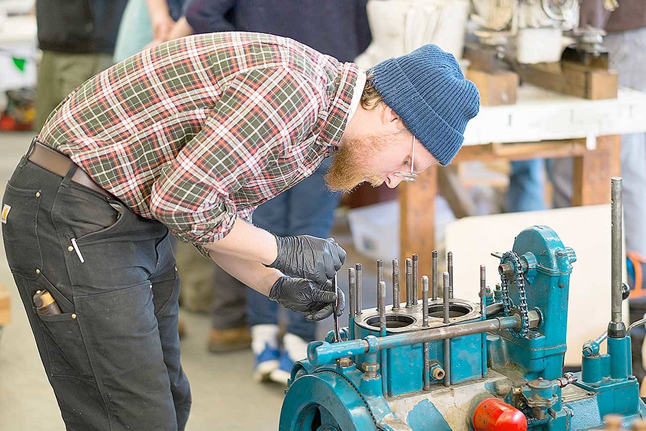 Tom Drews disassembles a diesel engine while studying in the Northwest School of Wooden Boatbuilding's Marine Systems program. The school has been awarded a $447,500 U.S. Economic Development Administration grant. (Photo courtesy of Northwest School of Wooden Boatbuilding)