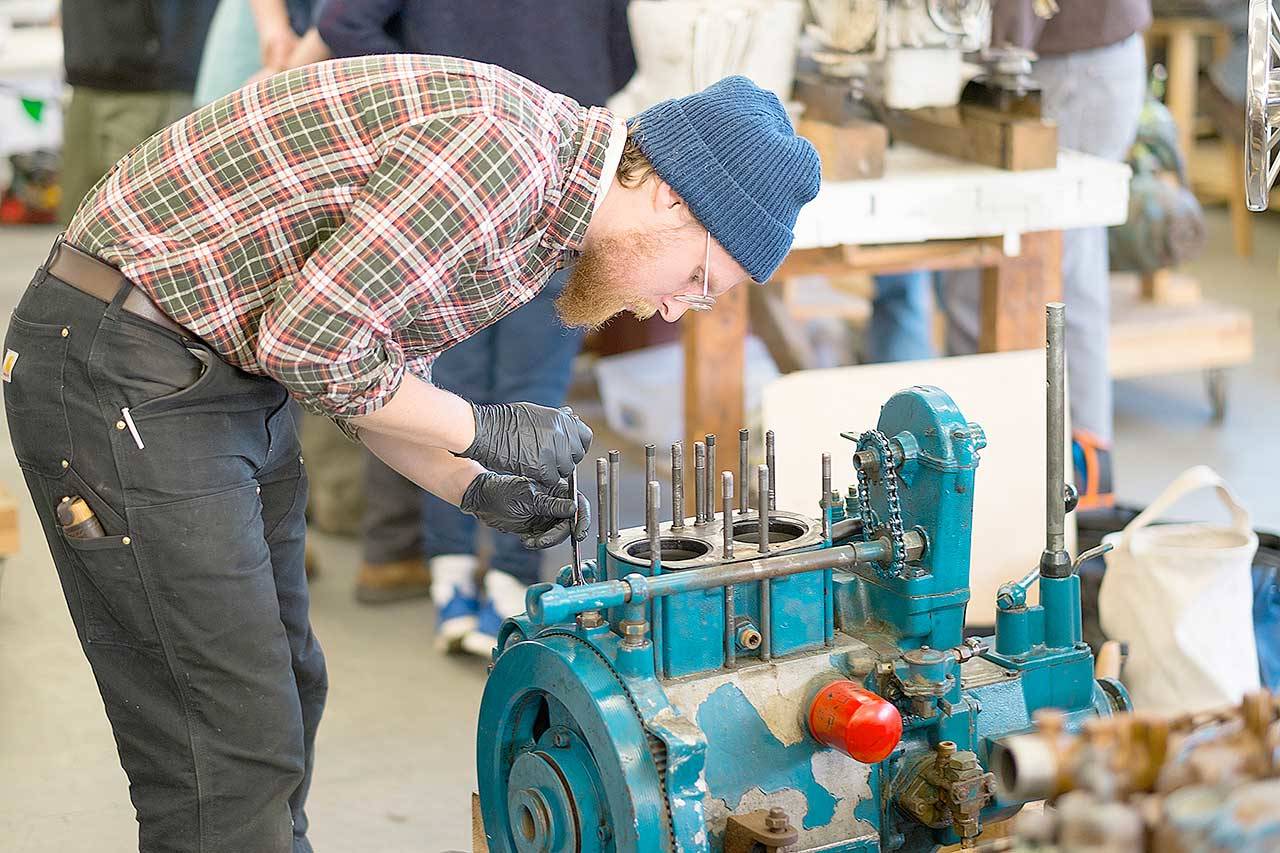 Tom Drews disassembles a diesel engine while studying in the Northwest School of Wooden Boatbuilding’s Marine Systems program. The school has been awarded a $447,500 U.S. Economic Development Administration grant. (Photo courtesy of Northwest School of Wooden Boatbuilding)
