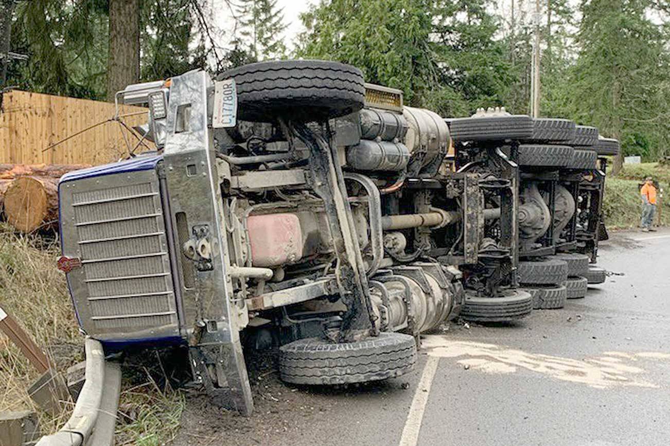 A log truck overturned on the onramp from state Route 117 to U.S. Highway 101 on Tuesday. (Washington State Patrol)