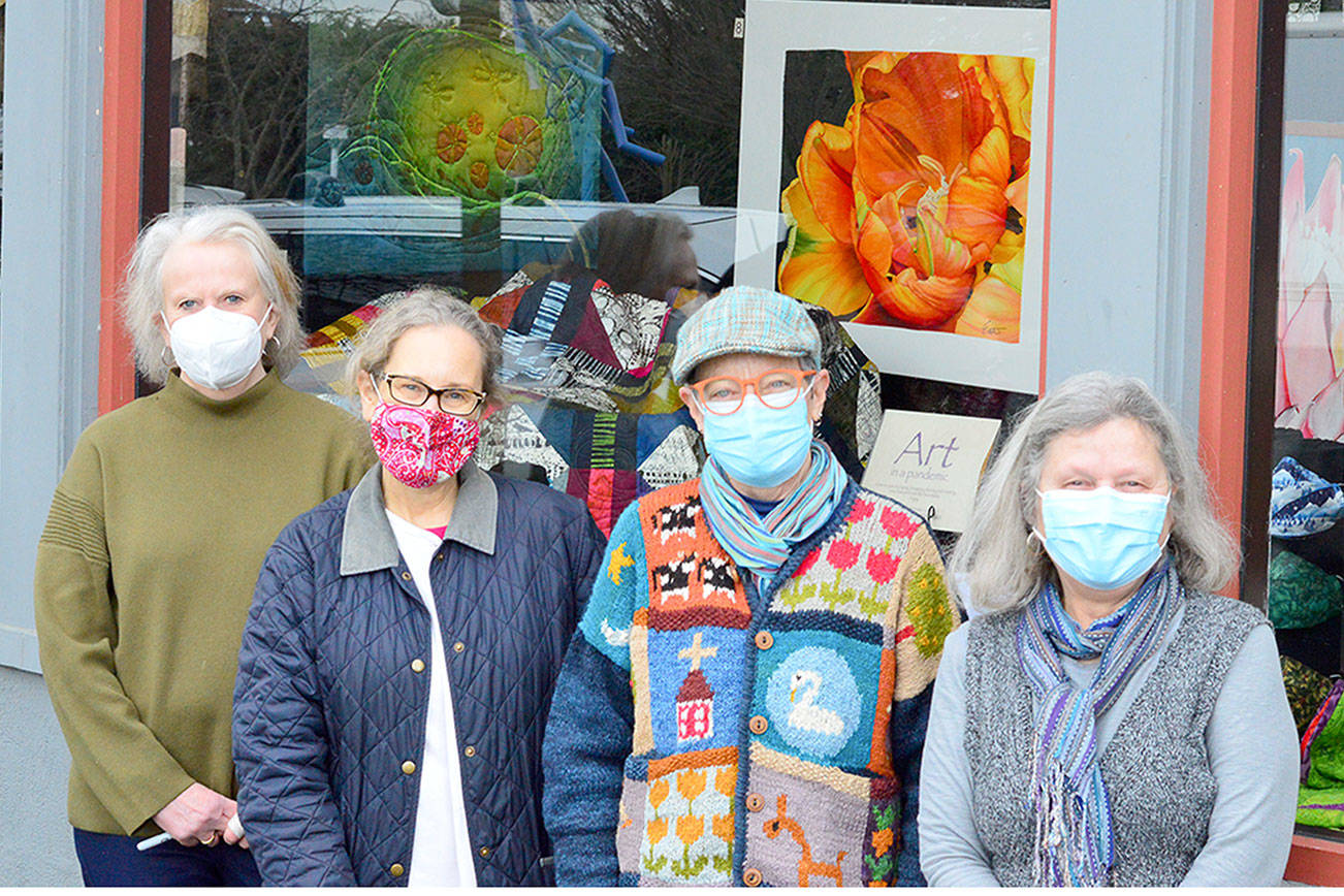 At the display window in Uptown Port Townsend are, from left, Jeri Auty, Cheri Kopp, Debra Olson and Sue Gale, contributors to the "Art in a Pandemic" show, on view around the clock at the corner of Tyler and Lawrence streets. (Diane Urbani de la Paz/Peninsula Daily News)