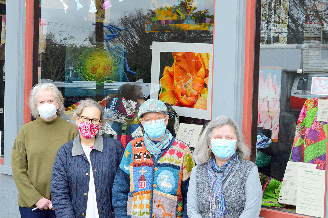 At the display window in Uptown Port Townsend are, from left, Jeri Auty, Cheri Kopp, Debra Olson and Sue Gale, contributors to the “Art in a Pandemic” show, on view around the clock at the corner of Tyler and Lawrence streets. (Diane Urbani de la Paz/Peninsula Daily News)