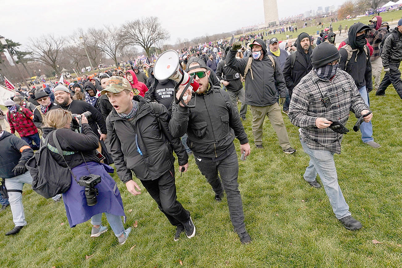 FILE - In this Wednesday, Jan. 6, 2021 file photo Ethan Nordean, with backward baseball hat and bullhorn, leads members of the far-right group Proud Boys in marching before the riot at the U.S. Capitol. Nordean, 30, of Auburn, Washington, has described himself as the sergeant-at-arms of the Seattle chapter of the Proud Boys. The Justice Department has charged him in U.S. District Court in Washington, D.C., with obstructing an official proceeding, aiding and abetting others who damaged federal property, and knowingly entering or remaining in a restricted building. He asked a judge Monday, Feb. 8, 2021, to release him from detention pending trial. (AP Photo/Carolyn Kaster,File)