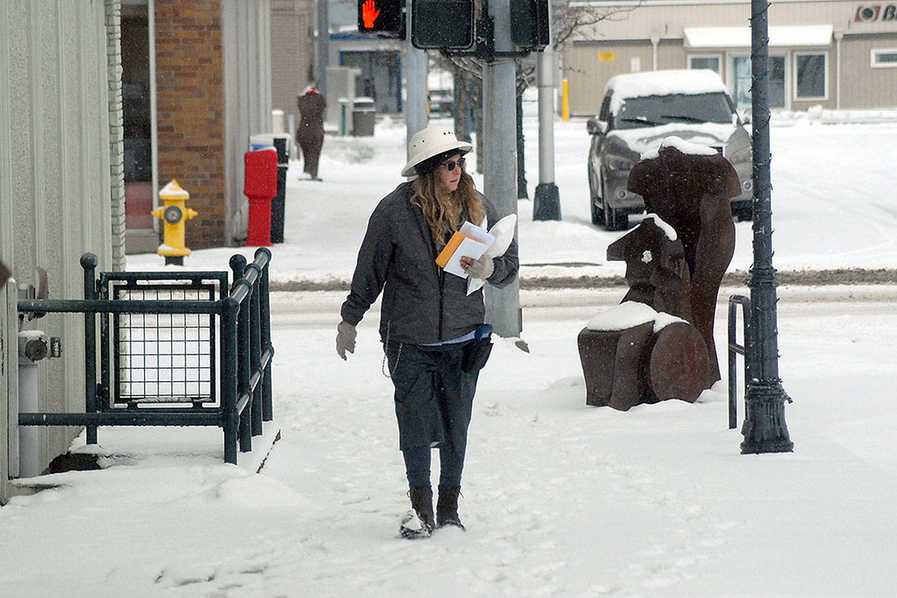 Keith Thorpe/Peninsula Daily News
U.S. Postal Service letter carrier Melinda McCoy makes her rounds on North Laurel Street in a snow-covered downtown Port Angeles on Saturday morning after several inches of snow blanketed the area  Friday night and into Saturday.