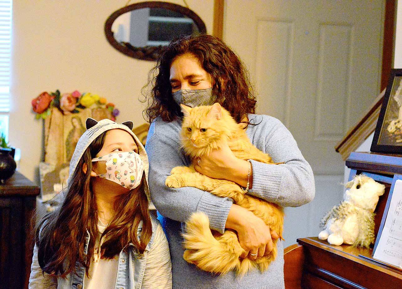 Natalia Guevara and her granddaughter Natali, 8, have been reunited with Honey the cat after nearly three months of searching. (Diane Urbani de la Paz/Peninsula Daily News)