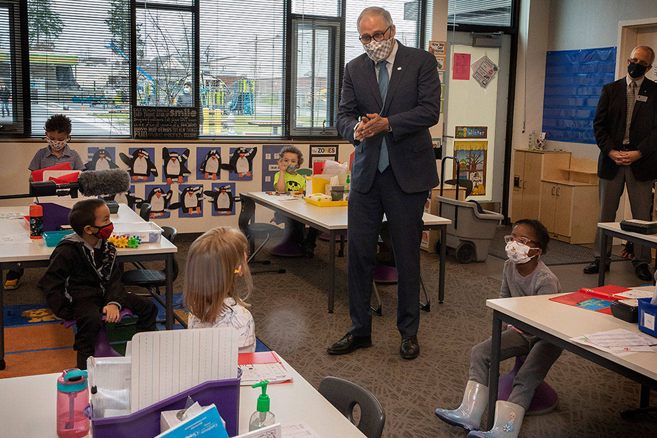 Washington Gov. Jay Inslee speaks with kindergartners in Chelsea Singh's class during a visit to Firgrove Elementary School in Puyallup, Wash., Thursday, Feb. 18, 2021. Students are back in school and all teachers and students are wearing masks. (Ellen M. Banner/The Seattle Times via AP, Pool)
