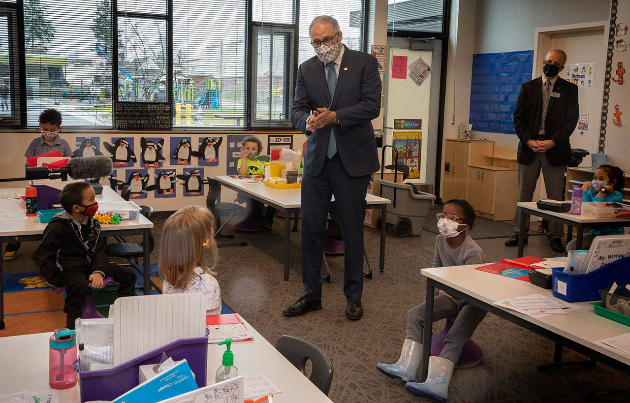 Gov. Jay Inslee speaks with kindergartners in Chelsea Singh’s class during a visit to Firgrove Elementary School in Puyallup on Thursday. Students are back in school and all teachers and students are wearing masks. (Ellen M. Banner/The Seattle Times via AP)