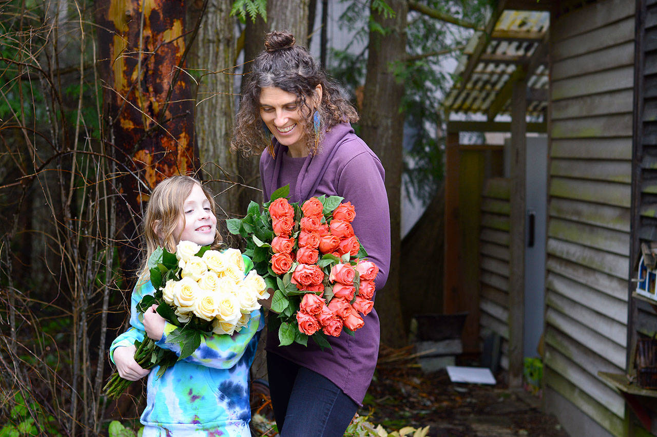 Farmer-florist Lexi Koch of Port Townsend and her son Jude, 8, unwrapped a few dozen roses Thursday for the extra-large floral heart garland to be placed at Haller Fountain on Monday. (Diane Urbani de la Paz/Peninsula Daily News)